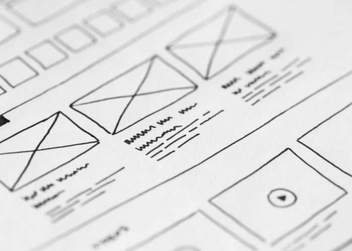 Detailed close-up of a hand-drawn wireframe design on paper for a UX project.